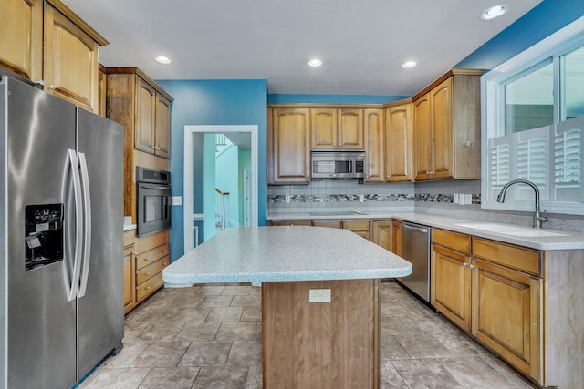 kitchen with decorative backsplash, a kitchen island, a sink, light countertops, and appliances with stainless steel finishes