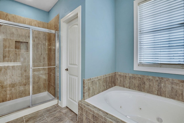 full bathroom featuring a shower stall and a tub with jets