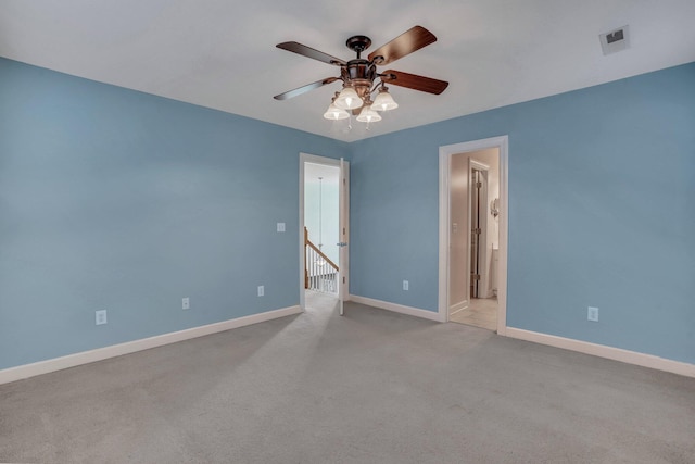 empty room with light carpet, visible vents, baseboards, and ceiling fan