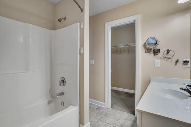 bathroom with vanity, a spacious closet, baseboards, tile patterned flooring, and bathtub / shower combination