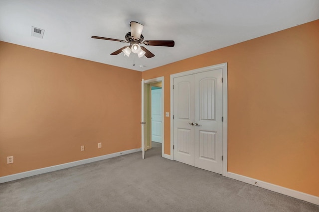 unfurnished bedroom with ceiling fan, visible vents, baseboards, light colored carpet, and a closet