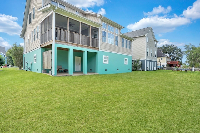 back of house with ceiling fan, a sunroom, a lawn, and a patio area