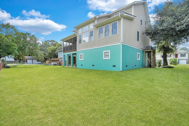 back of house featuring a sunroom, crawl space, a yard, and fence