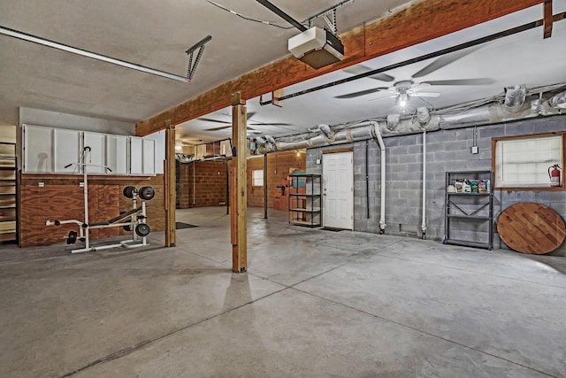 garage featuring concrete block wall and a garage door opener