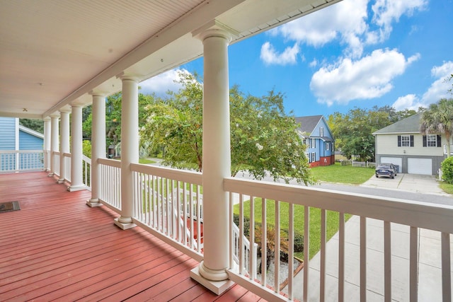 deck featuring a residential view, a lawn, and a porch