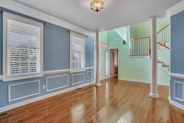 interior space with decorative columns, visible vents, and light wood-type flooring