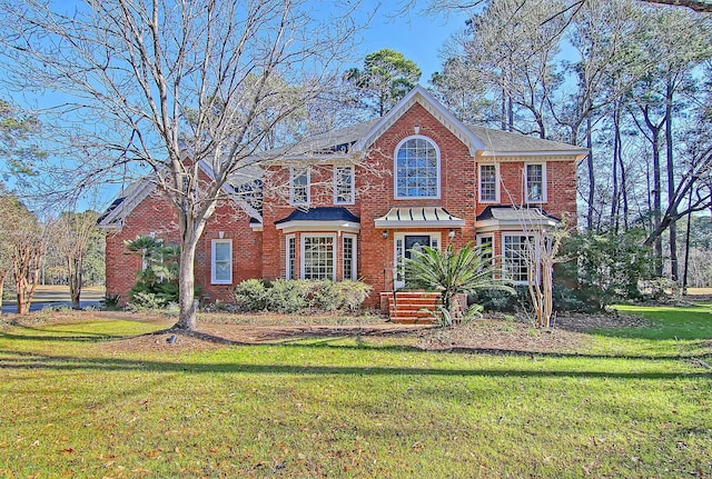 view of front facade with a front yard and brick siding