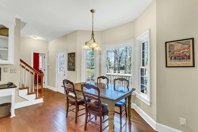 dining space featuring stairway, baseboards, and dark wood-type flooring