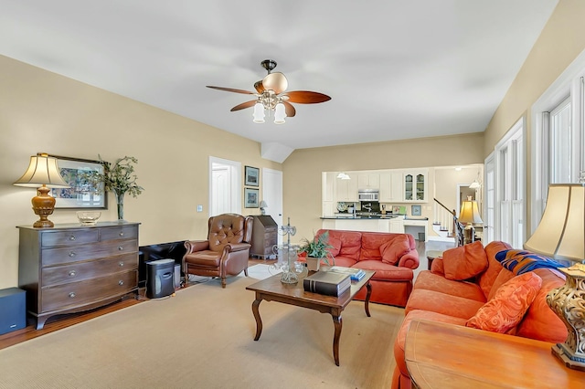 living area featuring stairway and a ceiling fan