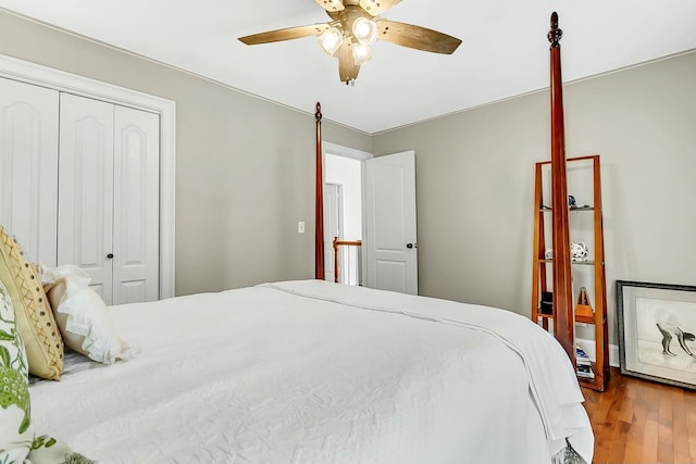 bedroom with a closet, wood finished floors, and a ceiling fan