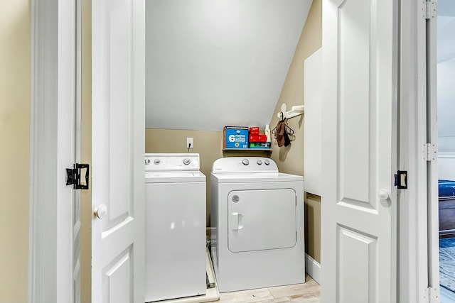 clothes washing area featuring laundry area, light wood finished floors, and washer and dryer