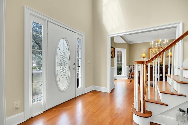 entryway featuring a notable chandelier, stairway, and wood finished floors