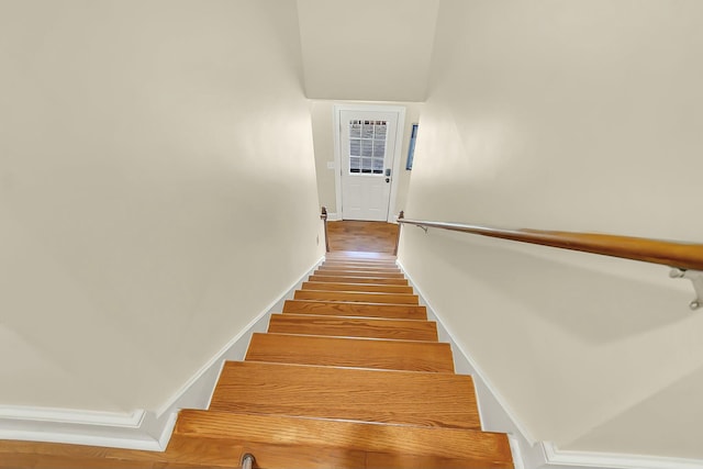 stairway with baseboards and wood finished floors