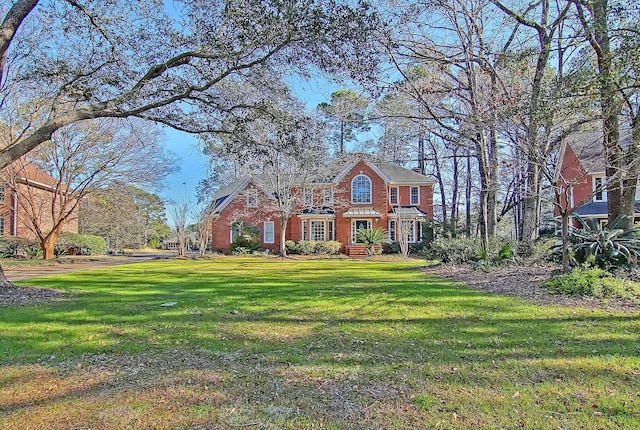 view of front of house featuring a front lawn and brick siding