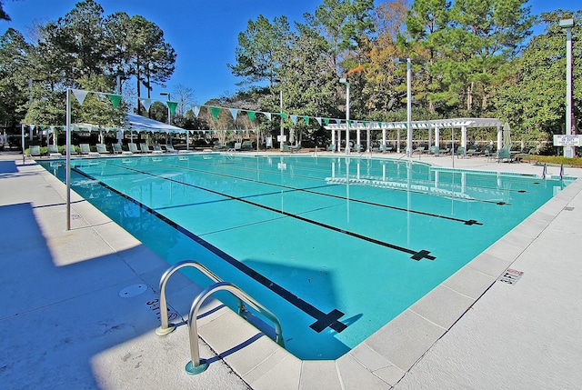 pool with a patio area and a pergola