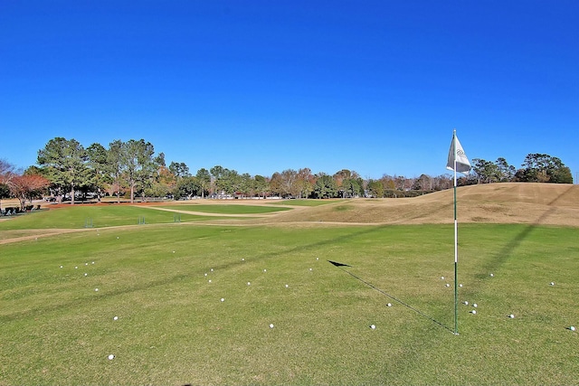 surrounding community featuring golf course view and a lawn