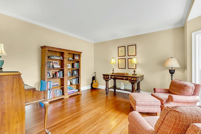 living area with light wood-style floors, ornamental molding, and baseboards