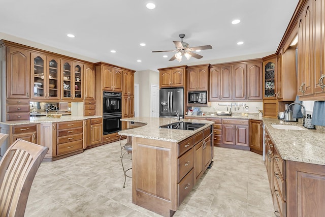 4702 Blockhouse Ln, Hollywood, SC 29449 - kitchen with a sink, black appliances, a kitchen bar, ceiling fan, and brown cabinets
