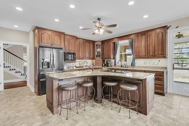4702 Blockhouse Ln, Hollywood, SC 29449 - kitchen featuring black appliances, a ceiling fan, a center island with sink, recessed lighting, and light stone counters