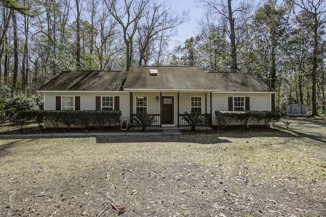 ranch-style house featuring an outbuilding, a storage unit, and covered porch