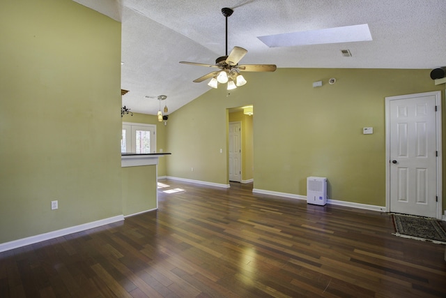 spare room featuring a textured ceiling, lofted ceiling with skylight, dark wood-style flooring, and visible vents