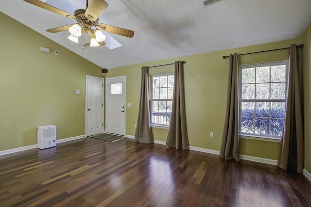 foyer entrance featuring a textured ceiling, baseboards, vaulted ceiling, and dark wood-type flooring