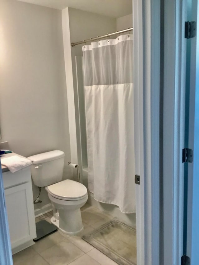 bathroom featuring curtained shower, tile patterned flooring, vanity, and toilet