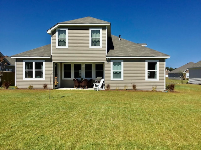 rear view of house featuring a patio area and a yard