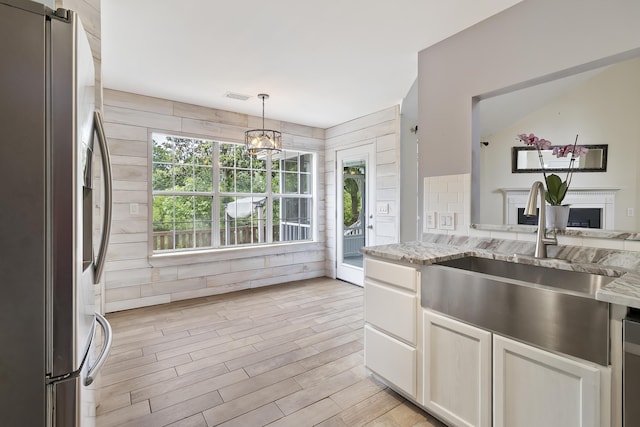 1245 Lakefront Dr, Charleston, SC 29412 - kitchen with freestanding refrigerator, a sink, light stone counters, a fireplace, and light wood-type flooring