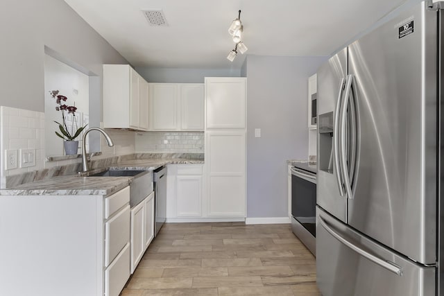 1245 Lakefront Dr, Charleston, SC 29412 - kitchen featuring appliances with stainless steel finishes, decorative backsplash, light wood-style flooring, white cabinets, and a sink