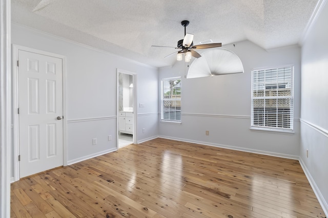 1245 Lakefront Dr, Charleston, SC 29412 - unfurnished bedroom with a textured ceiling, crown molding, light wood-style flooring, ensuite bath, and baseboards