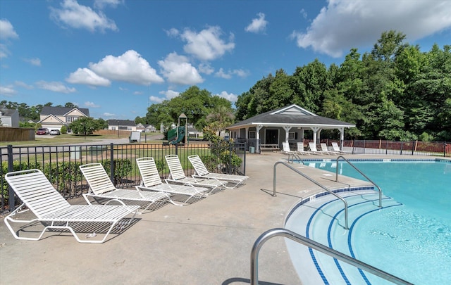 pool featuring a patio, fence, and playground community