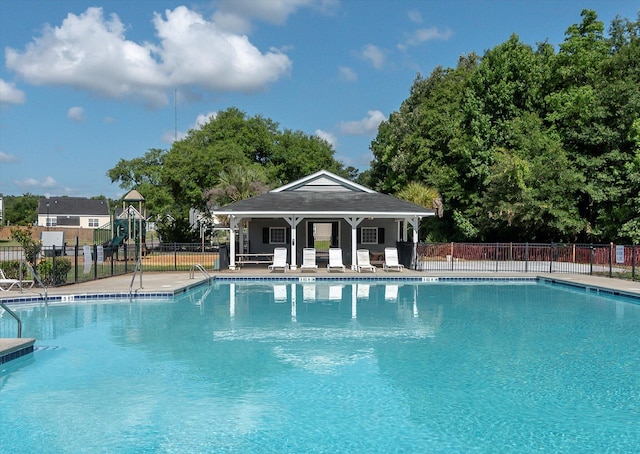 community pool with a patio area and fence