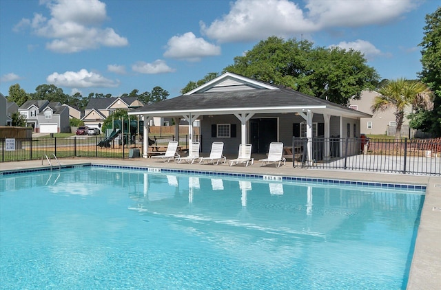 pool with a patio area and fence