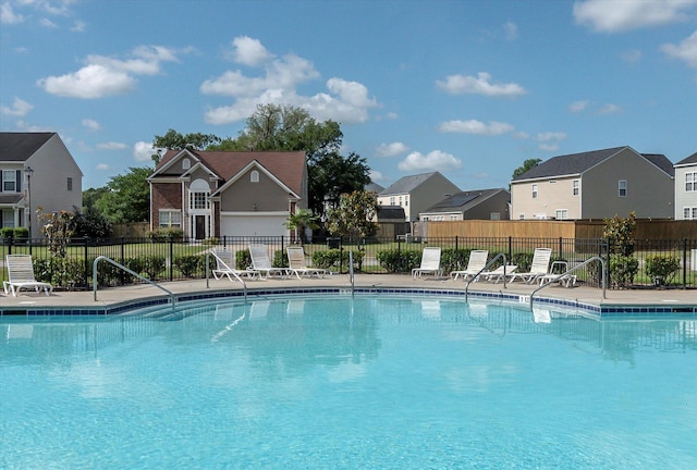 community pool with fence and a residential view