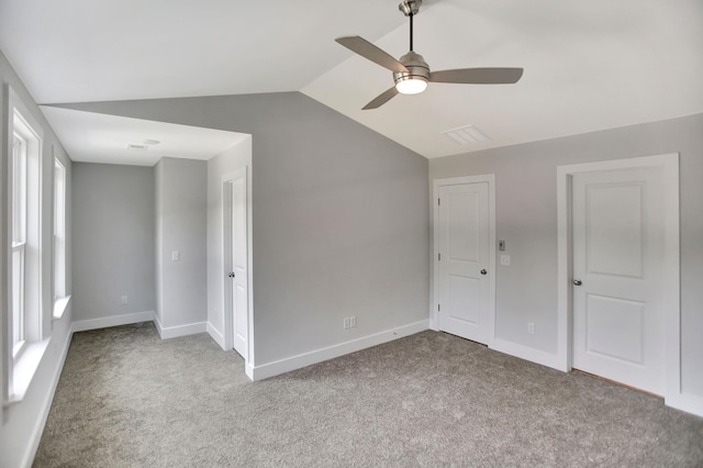 interior space with ceiling fan, lofted ceiling, and light carpet