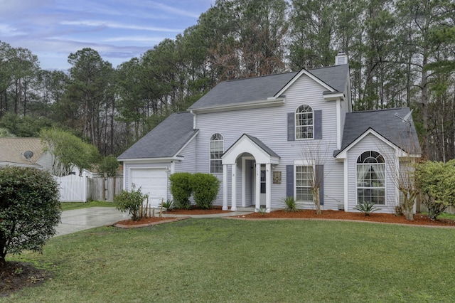 view of front of property featuring driveway, a garage, a chimney, fence, and a front yard