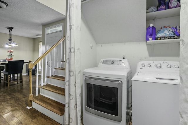 laundry room with laundry area, baseboards, wood finished floors, washing machine and clothes dryer, and a textured ceiling