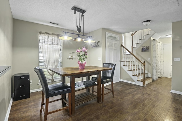 dining room featuring stairway, wood finished floors, visible vents, and baseboards