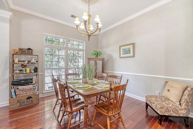 dining space featuring crown molding, wood finished floors, a notable chandelier, and visible vents