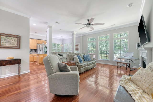 living room featuring ornate columns, crown molding, ceiling fan, and visible vents