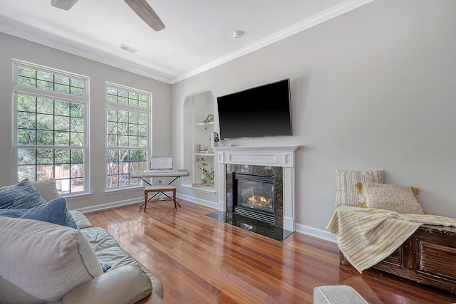 living room with crown molding, arched walkways, wood finished floors, a high end fireplace, and visible vents