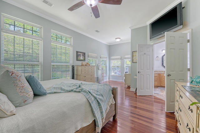 bedroom featuring visible vents, multiple windows, ornamental molding, and hardwood / wood-style flooring
