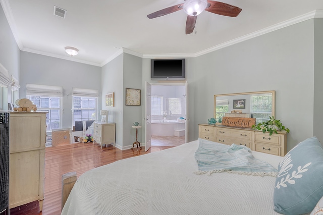 bedroom featuring a ceiling fan, baseboards, wood finished floors, visible vents, and ornamental molding