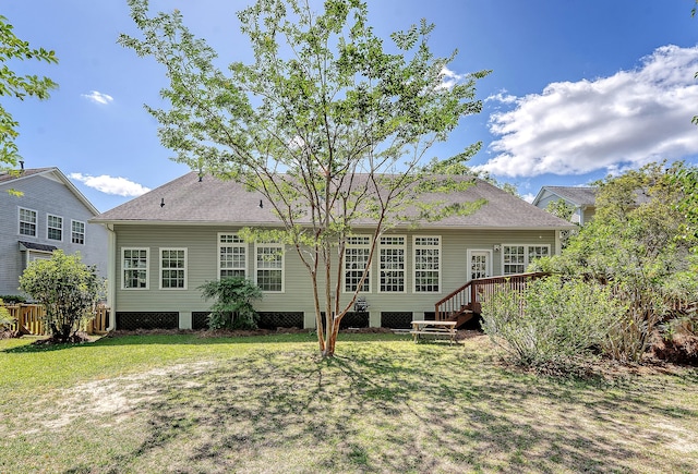 back of property featuring roof with shingles, a wooden deck, a yard, and fence