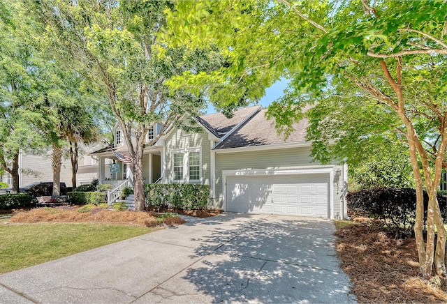 view of front of property with covered porch, a front yard, roof with shingles, concrete driveway, and an attached garage
