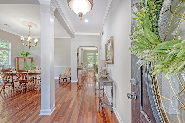 entryway featuring visible vents, arched walkways, hardwood / wood-style flooring, baseboards, and ornamental molding