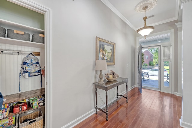 entrance foyer featuring baseboards, ornamental molding, hardwood / wood-style flooring, and visible vents