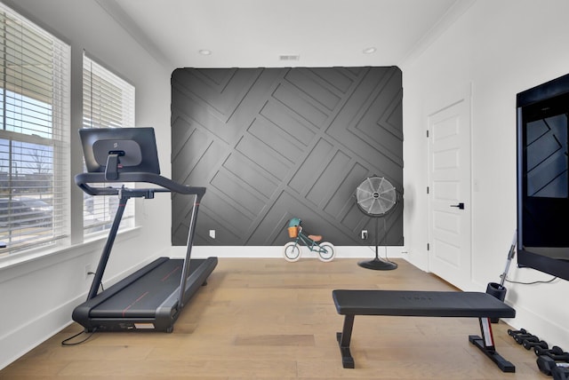 workout area featuring recessed lighting, baseboards, wood finished floors, and an accent wall