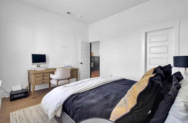 bedroom featuring visible vents and wood finished floors